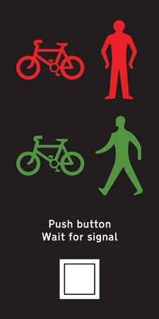 The signal panel of a toucan crossing. A red bicycle and a red standing figure appear above a green bicycle and a green walking figure, showing that cyclists and pedestrians cross together, with the instruction "Push button, Wait for signal" above the button itself.