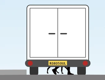 The back of a van from road level. The doors and number plate give nothing away, but a pair of legs is visible in the gap beneath the vehicle, the only clue that someone is walking across in front of it.