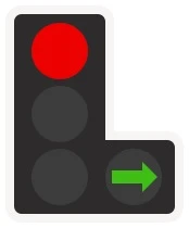 A traffic signal showing red, with a separate filter head beside it lit by a green arrow pointing right. Traffic turning right may go while the main signal still holds everything else.