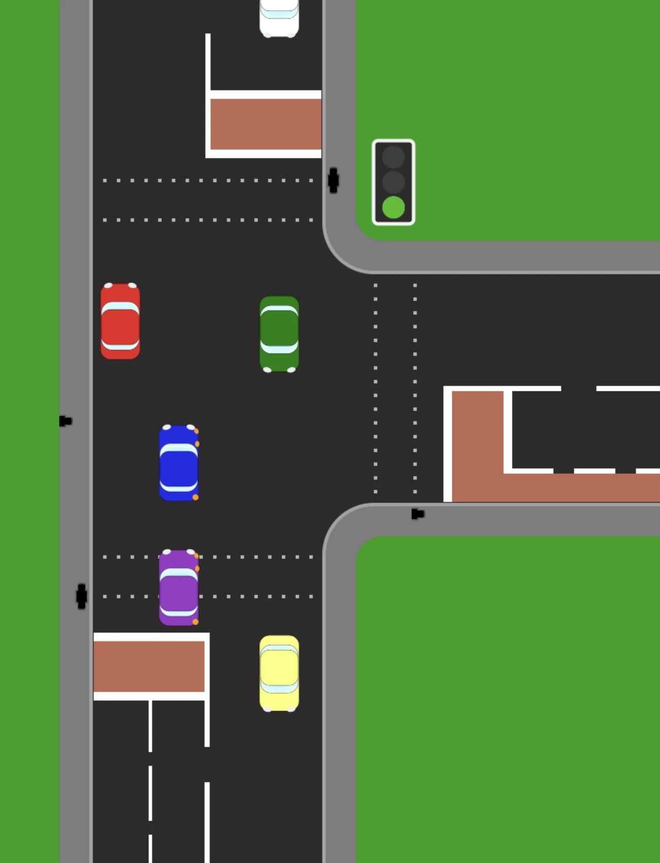 A light-controlled junction from above with the signal showing green. Cars are queued in two lanes on the approach road, and a side road opens to the right beyond the junction.